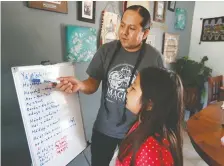  ??  ?? TJ Warren teaches his daughter Kiihibaa Warren Diné in their dining room. The family has always spoken and tried to teach both Diné and Cree languages at home and TJ figured “if we have to home-school, let’s focus on our approach as Indigenous people to the curriculum and Indigenize it.”