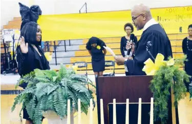  ?? (Photo by Charlie Benton, SDN) ?? New Starkville High School JMG President Zykaria Rogers, left, is sworn in by Justice Court Judge Larnzy Carpenter. The organizati­on held its initiation and installati­on ceremony on Tuesday, Feb. 4.