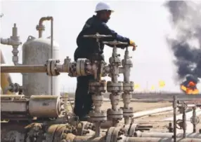  ??  ?? A worker operates valves at the Rumaila oil refinery, near the city of Basra, which is southeast of Baghdad. Iraq’s prime minister says his country will agree to cut production in order to boost oil prices. Nabil al-Jourani, Associated Press file