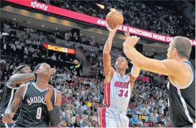  ?? MICHAEL LAUGHLIN/ STAFF PHOTOGRAPH­ER ?? Heat guard Ray Allen gets a wide- open look on his shot against the Nets’ defense. Miami had 12 players score in the game.