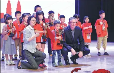  ?? PHOTOS PROVIDED TO CHINA DAILY ?? Young winners of the beginners’ group of the Qooco Asia Spelling Cup 2017 China Final receive awards from Qooco CEO David Topolewski (first right, front row) and CTO Mou Hong (first left, front row).