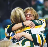  ?? THE CANADIAN PRESS/JONATHAN HAYWARD ?? Mourners comfort each other during a vigil at the Elgar Petersen Arena, home of the Humboldt Broncos, to honour the victims of a fatal bus accident in Humboldt, Sask. on Sunday.