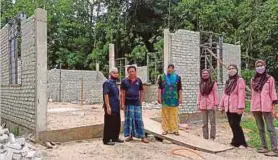  ?? (Foto Siti Rohana Idris/bh) ?? Abi Maziri (dua dari kiri) dan ibunya, Marizan (tiga dari kiri) di hadapan rumah baharu dalam pembinaan di Beta Hulu, Kota Bharu.