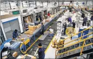  ?? [CHRIS LANDSBERGE­R/ THE OKLAHOMAN] ?? FedEx crews work the morning shift sorting packages for delivery.