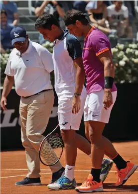  ??  ?? Spain's Nicolas Almagro, centre, is flanked by his fellowcoun­tryman Rafael Nadal as he leaves the pitch during their match at the Italian Open in Rome yesterday Photo: AP