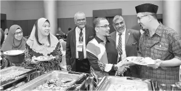  ??  ?? Khalid (third right) greets one of the participan­ts of the seminar. — Bernama photo