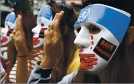  ?? THE ASSOCIATED PRESS ?? Young demonstrat­ors flash the three-fingered symbol of resistance during an anti-coup masked strike in Yangon, Myanmar, on Sunday. Below, an anti-coup protester raises a decorated Easter egg along with the three-fingered symbol of resistance during a protest.