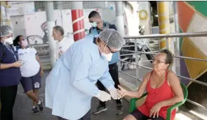  ??  ?? The Associated Press
A city health worker takes a resident’s blood sample during a city new program that aims to administer 20 thousand COVID-19 tests in Rio de Janeiro’s poor neighborho­ods.