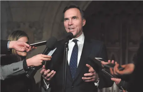  ?? CP PHOTO ?? Minister of Finance Bill Morneau speaks to reporters in the foyer of the House of Commons after announcing the date of the next federal budget on Tuesday.