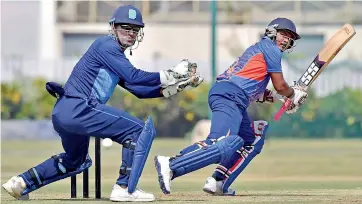  ??  ?? Jharkhand wicketkeep­er Mahendra Singh Dhoni looks on as Services batsman Gaurav Kocher plays a shot during their Vijay Hazare Trophy match at Kalyani in West Bengal on Tuesday. — PTI