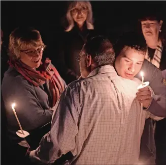  ?? PHOTOS BY SEAN D. ELLIOT THE DAY ?? Above, Joseph Parise, center, is comforted Thursday by those gathered for a candleligh­t vigil in memory of his brother Robert Parise and all victims of domestic violence, sexual assault, stalking and traffickin­g, at Safe Futures in New London. Right, staff and supporters of Safe Futures hold candles during the vigil. Robert Parise, a client of Safe Futures, allegedly was murdered by his ex-partner on Oct. 4.