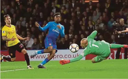  ?? REUTERS PIC ?? Watford goalkeeper Heurelho Gomes saves an attempt from Arsenal’s Alex Iwobi (centre) at Vicarage Road on Saturday.
