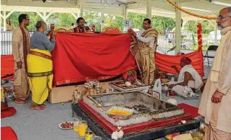  ??  ?? Hindu priests make preparatio­ns for the incarnatio­n of deities. This year marks the first time the event was to be held at the organizati­on’s new home.