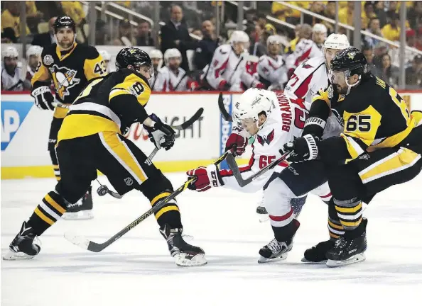  ?? PHOTOS: GREGORY SHAMUS/GETTY IMAGES ?? Washington Capitals left wing Andre Burakovsky skates between Pittsburgh Penguins defencemen Brian Dumoulin and Ron Hainsey in Game 6 of their Eastern Conference semifinal on Monday in Pittsburgh. Burakovsky had two unassisted goals in the win.