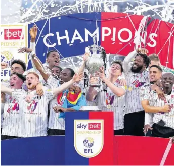  ?? AP ?? Fulham players celebrate with the trophy after winning the English Football League Championsh­ip with a 7-0 routing of Luton Town at Craven Cottage, London, England yesterday.