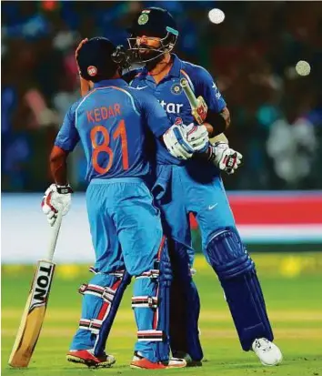  ?? Reuters ?? Indian captain Virat Kohli hugs teammate Kedar Jadhav as he celebrates after reaching his century during the first One Day Internatio­nal against England in Pune yesterday.