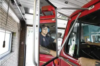  ?? BILL LACKEY / STAFF ?? Springfiel­d firefighte­r Skyler Baise checks his mirrors as he backs the fire engine into the tiny garage bay at Fire Station No. 3 on Thursday.
