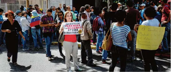  ?? Foto: Federico Parra, afp ?? Bei Protesten in der Hauptstadt Caracas fordert eine Demonstran­tin Hilfe für Parkinson Patienten, die aufgrund der Krise im Land keine Medizin mehr bekommen.