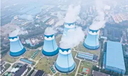 ?? CHINATOPIX ?? Steam billows from cooling towers at a coal-fired power station Sept. 27 in Nanjing, China. The world is in an energy crunch as winter looms and the pandemic continues.