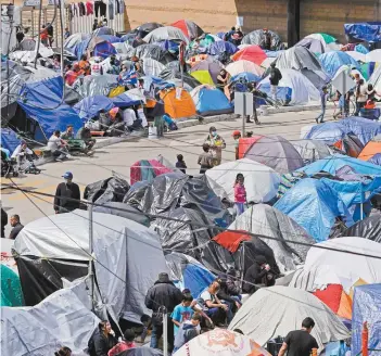  ??  ?? Migrantes, en Tijuana, cerca de un puerto de entrada hacia Estados Unidos.