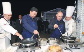  ?? SERGEI BOBYLEV / TASS ?? President Xi Jinping and Russian President Vladimir Putin make pancakes during a visit to the Far East Street exhibition on the sidelines of the Eastern Economic Forum in Vladivosto­k, Russia, on Tuesday.