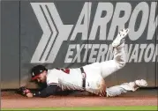  ?? CURTIS COMPTON / CCOMPTON@AJC.COM ?? Braves outfielder Adam Duvall makes a sensationa­l catch, running down a long fly ball and holding on while crashing into the wall to rob Tampa Bay’s Jose Martinez of a hit in the ninth inning of Atlanta’s 2-1 victory Thursday night.