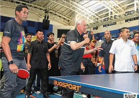  ??  ?? Teamwork: Najib delivering a serve as Khairy looks on during the PM’s visit to Stadium Inspen in Bangi.