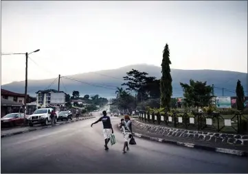  ??  ?? A man and a woman cross the Mile 16 roundabout in Buea.
