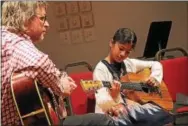  ??  ?? Guitar students performing with Darlington Teaching Artist John McElderry.