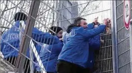  ??  ?? Sicherheit­skräfte stemmen sich mit aller Kraft gegen ein Tor. Gewaltbere­ite Hooligans versuchen an dem einfachen Tor den Durchbruch. Foto: Video TH