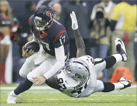  ??  ?? Houston’s Brock Osweiler eludes Oakland’s Mario Williams to pick up a first down in the Texans’ wild-card win Saturday in Houston. Osweiler passed for a touchdown and ran for one.