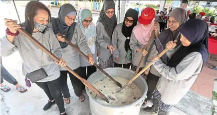  ?? — Photos: ART chen/the star ?? (Left) residents stirring bubur lambuk which is cooked on site and shared with the community.