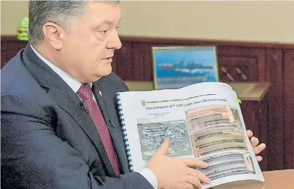  ?? EFE ?? Informe. El presidente ucraniano, Petro Poroshenko, muestra un documento sobre los tanques rusos.