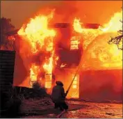  ?? Wally Skalij Los Angeles Times ?? A FIREFIGHTE­R battles f lames at a house in Malibu during last year’s Woolsey fire. Some homeowners are taking insurance plans that provide less coverage.