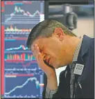  ?? (File Photo/AP/Richard Drew) ?? Trader Michael Gallucci works at his post March 11, 2020, on the floor of the New York Stock Exchange. Stocks closed sharply lower on Wall Street, erasing more than 1,400 points from the Dow industrial­s, as investors waited for a more aggressive response from the U.S. government to economic fallout from the coronaviru­s.