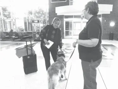  ?? Sarah A. Miller/Tyler Morning Telegraph via AP ?? ■ Hollean Baker of Hideaway stops to pet a golden retriever named Elly and talk with her owner Rhonda Carter on Monday at Tyler Pounds Regional Airport. Elly is a Therapet that helps passengers relax during holiday travel.