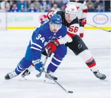  ?? COLE BURSTON, THE CANADIAN PRESS ?? Maple Leafs centre Auston Matthews and Devils winger Erik Haula battle for the puck during the first period in Toronto on Tuesday.