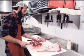  ?? Ned Gerard / Hearst Connecticu­t Media ?? Tom Monahan cuts roast portions from a leg of lamb at Stone Gardens Farms in Shelton on Thursday.