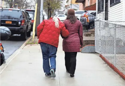  ?? SETH HARRISON/THE JOURNAL NEWS ?? Maggie Ornstein, 44, takes her mother, Janet, 77, for a walk in their Queens neighborho­od on March 24, 2022. Janet suffered a cerebral aneurysm in 1996 when Maggie was 17 years old. She suffered cognitive impairment and has required constant caregiving ever since. Maggie, who holds a doctoral degree and three master’s degrees, has spent her entire adult life living with and caring for her mother.