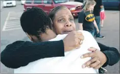  ?? — Photo by The Associated Press ?? Shamecca Davis hugs her son Isaiah Bow, who was an eye witness to the shooting, outside Gateway High School where witnesses were brought for questionin­g Friday.