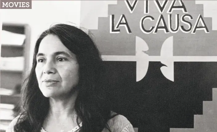  ?? Copyright Cathy Murphy ?? Labor activist Dolores Huerta stands in front of the UFW’s Huelga flag, mid-1970s. She is the subject of a documentar­y executive produced by Carlos Santana.