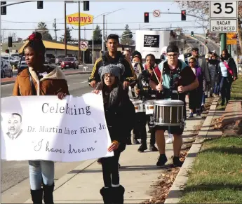  ??  ?? Dozens of people marched through the streets of Marysville on Saturday as part of the 21st annual Unity March to honor Dr. Martin Luther King Jr. BELOW: People marching held signs honoring Dr. Martin Luther King Jr.