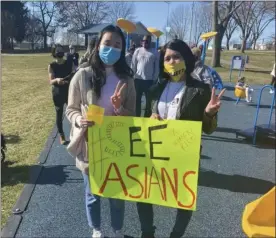  ?? PHOTO COURTESY DANIELLE KWOCK PHILLIPS ?? Danielle Kwock Phillips, an organizer with PA Women Rise, right, holds a sign with Maggie Jiang, left, while attending the Vigil for Victims of Anti-Asian Hate Crimes at Sutcliffe Park in Conshohock­en. Phillips was one of the speakers during the March 21 event.