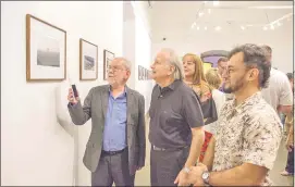  ??  ?? Jesús Ruiz Nestosa (i) aquí mostrando su fotografía al cineasta Carlos Saguier y otros visitantes de los muchos que llegaron hasta El Cabildo.