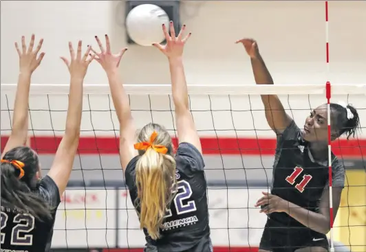  ?? Katharine Lotze/The Signal (See additional photos on signalscv.com) ?? Hart’s Ashley Cosey (11) goes for a kill over Valencia’s Lauren Russ (12), center, and Natalie Ellias (22), left, during a volleyball game on Tuesday.