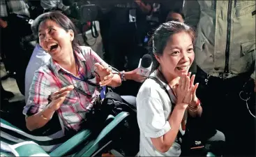  ?? LILLIAN SUWANRUMPH­A / AFP ?? Family members — camping out near Tham Luang cave in Thailand’s Khun Nam Nang Non Forest Park — celebrate upon hearing the news that all members of their children’s soccer team and its coach were found alive late on Monday.