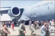  ?? Associated Press ?? Hundreds of people run alongside a U.S. Air Force C-17 transport plane as it moves down a runway of the internatio­nal airport, in Kabul, Afghanista­n on Monday,