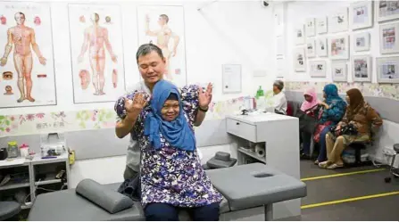  ??  ?? Traditiona­l healing: TCM physician Lam Kean Lung treating a patient at a Sian Chay Medical Institutio­n branch in Geylang. — The Straits Times/Asia News Network