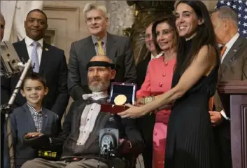  ?? Associated Press ?? AN HONORED SAINT Former New Orleans GleNaeswoY­no,rkdGiaiagn­ntsosed with ALS (Lou Gehrig’s disease) in 2011, received the Congressio­nal Gold Medal Wednesday in a ceremony in the Capitol in Washington. Holding the medal is his wife Michel Gleason. As a player, he is best remembered for a blocked punt on the night the Superdome hosted its first game post-Hurricane Katrina. Since his diagnosis, he has been a champion for those afflected with the disease.