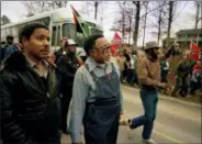  ?? GENE BLYTHE — THE ASSOCIATED PRESS FILE ?? Atlanta city councilman, Rev. Hosea Williams, in overalls, leads a march against efforts to keep Forsyth County in Georgia all white past counter-protesters near Cumming, Ga., as a crowd waves Confederat­e flags and jeer the marchers. Racial stereotype­s and racist imagery in popular culture seemed to be everywhere in the chaotic 1980s when future Virginia Gov. Ralph Northam and future Attorney General Mark Herring admitted dressing up in blackface.